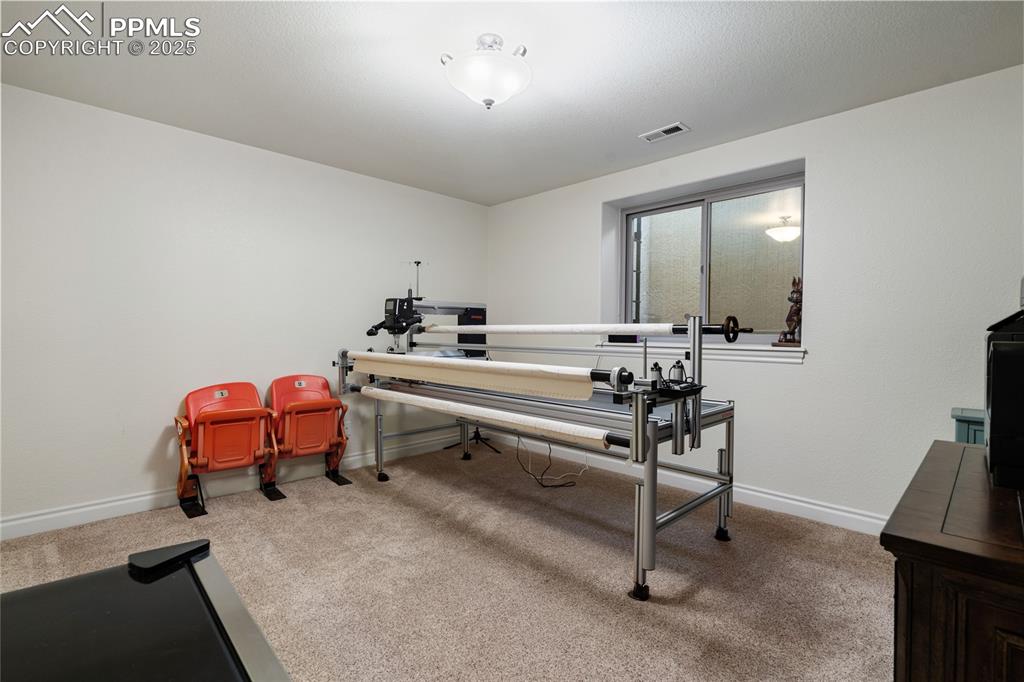 Carpeted home office featuring baseboards