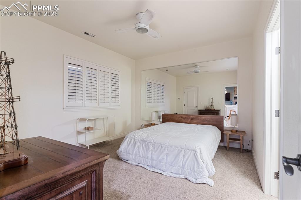 Carpeted bedroom featuring ceiling fan