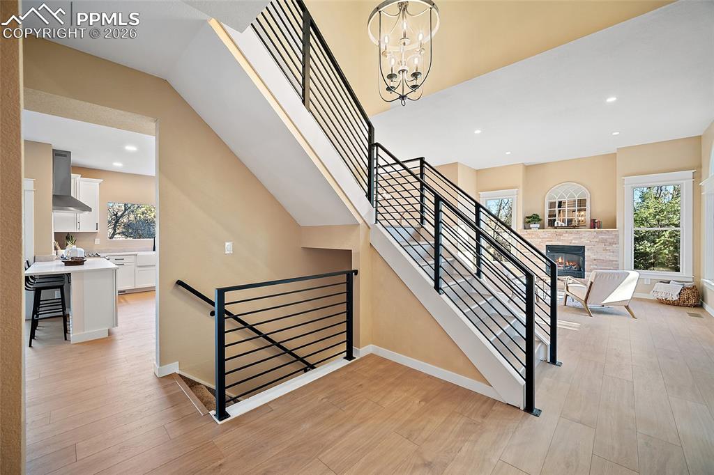 View from front hall to living room, upstairs to 3 bedrooms and laundry room, and basement entry