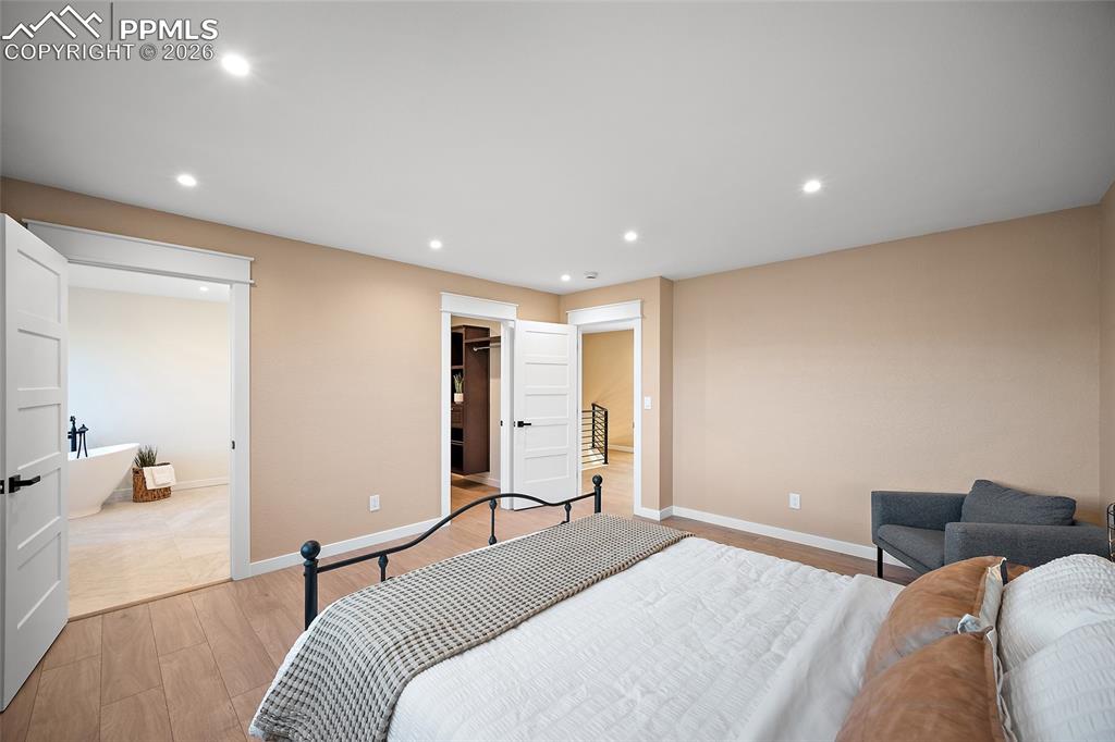 Primary bedroom with recessed lighting, a spacious closet, and primary bath