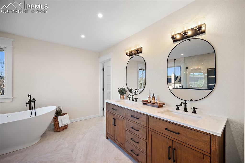 Luxurious, spa inspired primary bath featuring double vanity, a freestanding soaking tub, recessed lighting, and an enclosed spa shower