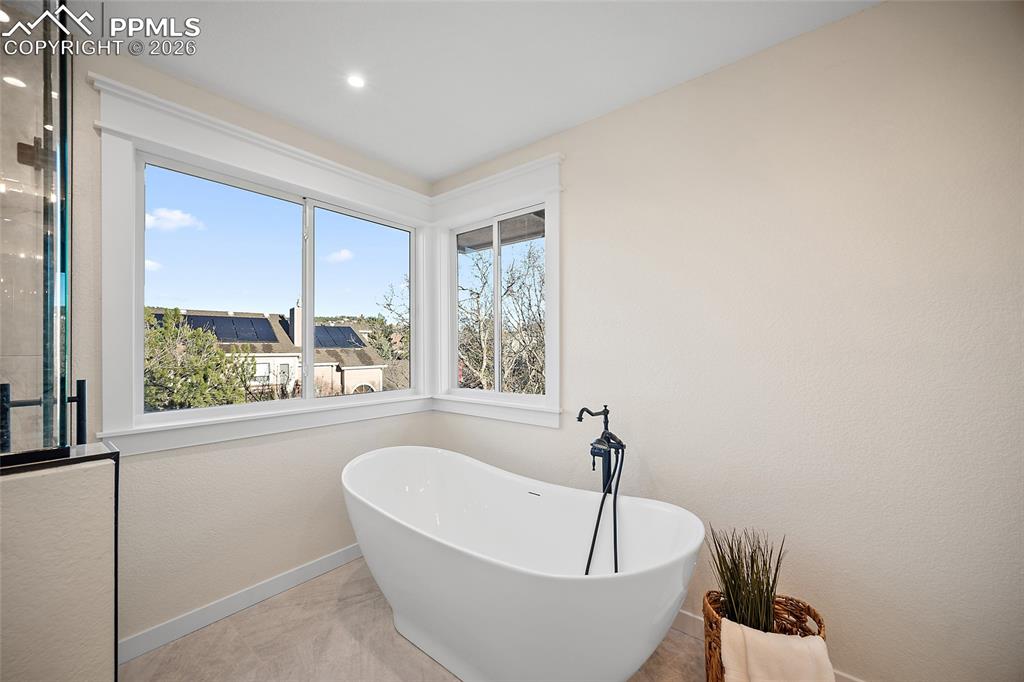 Primary bath featuring a luxurious soaking tub and view