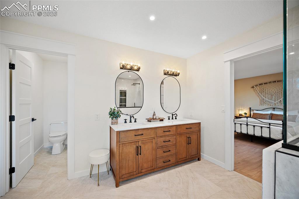 Primary bathroom featuring double vanity, ensuite bathroom, and recessed lighting