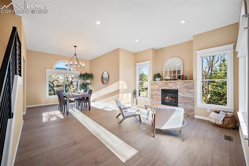 Living area featuring abundant natural light, LVP flooring, high ceilings, and fire place