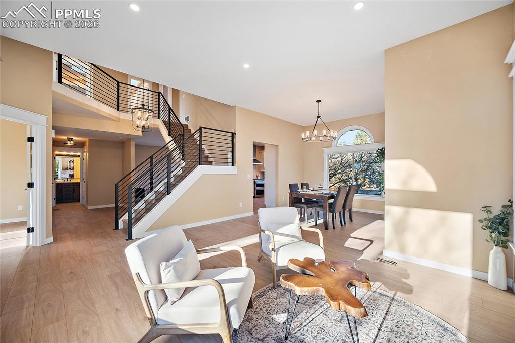 Living area featuring warm natural light, LVP flooring, and high ceilings