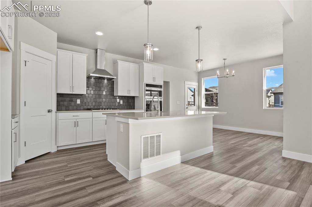 Kitchen equipped with quartz countertops, a center island, crown moulding, and stainless appliances
