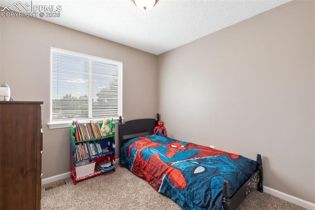 Bedroom featuring carpet floors and a textured ceiling