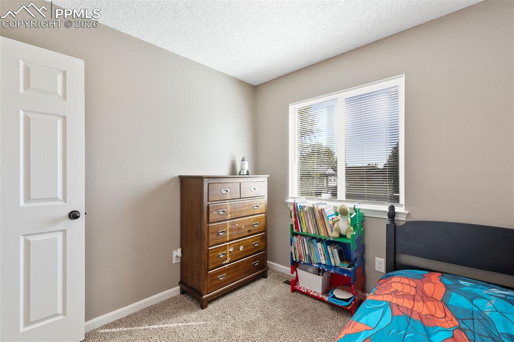 Bedroom featuring light carpet and a textured ceiling