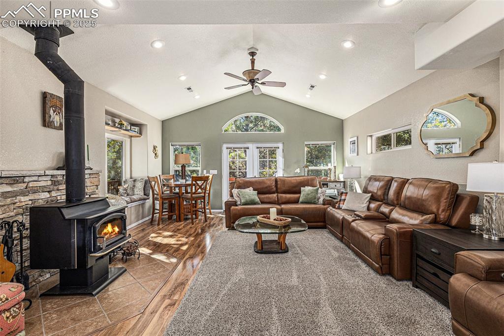 Dining area with a textured wall, wood finished floors, and vaulted ceiling