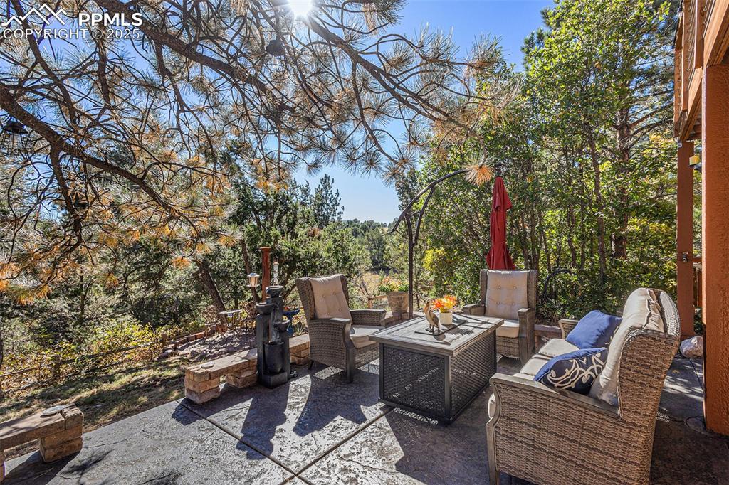 Rear view of property with a patio, stucco siding, an outdoor fire pit, and a chimney