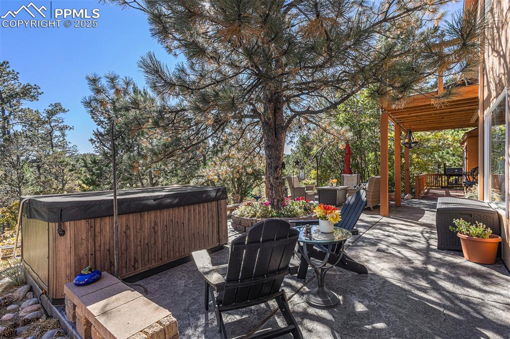 Wooden terrace featuring grilling area and view of wooded area
