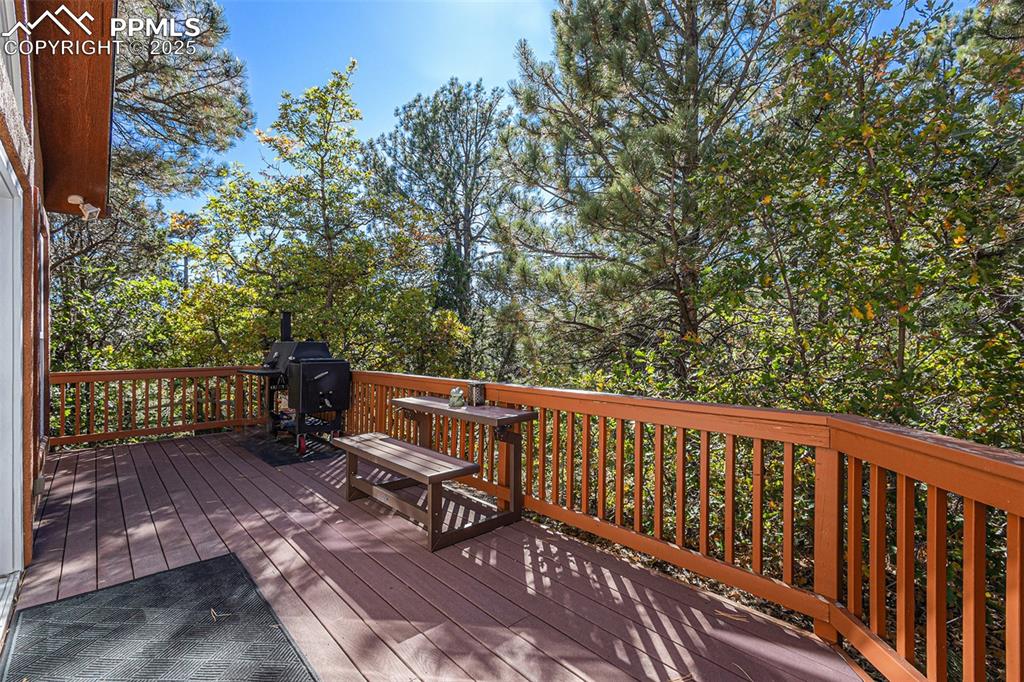 Bedroom featuring vaulted ceiling, dark wood finished floors, multiple windows, ceiling fan, and ensuite bathroom