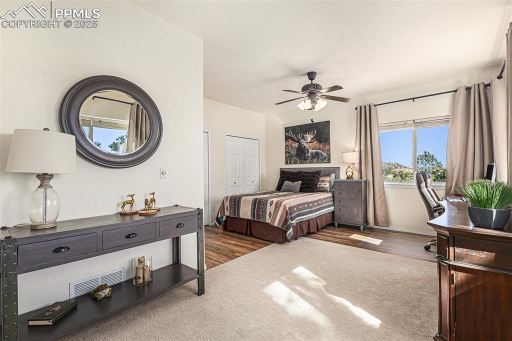Bedroom featuring dark wood finished floors, a ceiling fan, and a closet