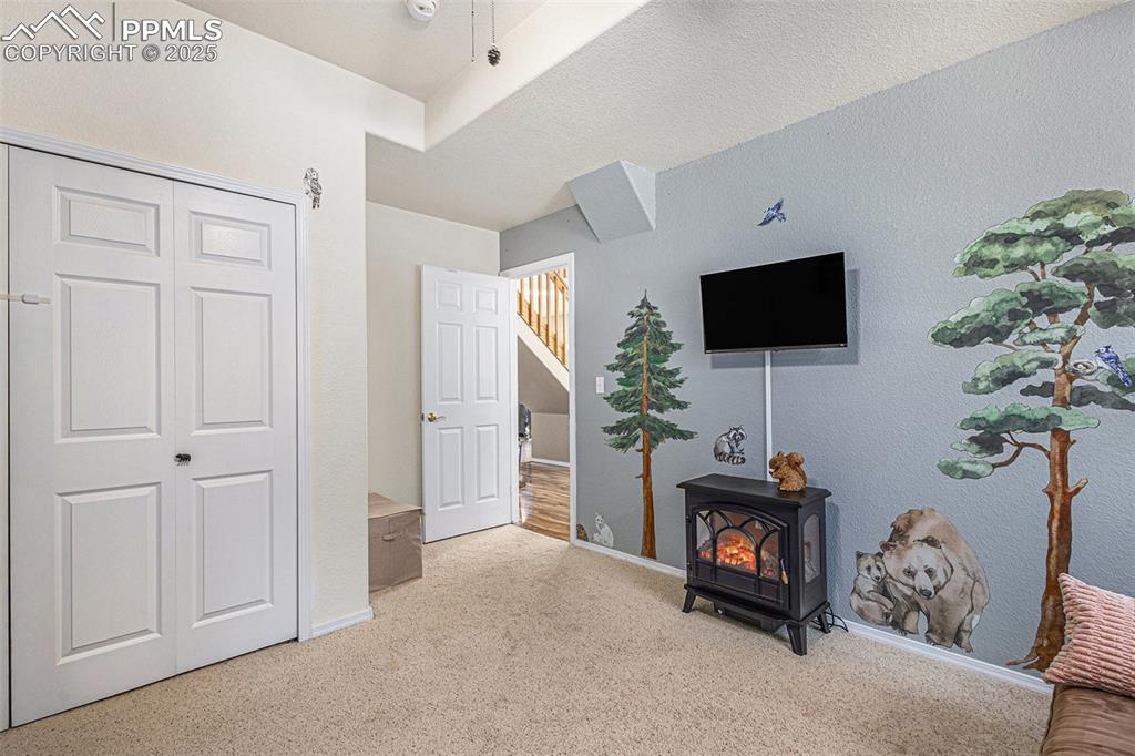Hallway featuring a skylight, wood finished floors, a chandelier, and high vaulted ceiling