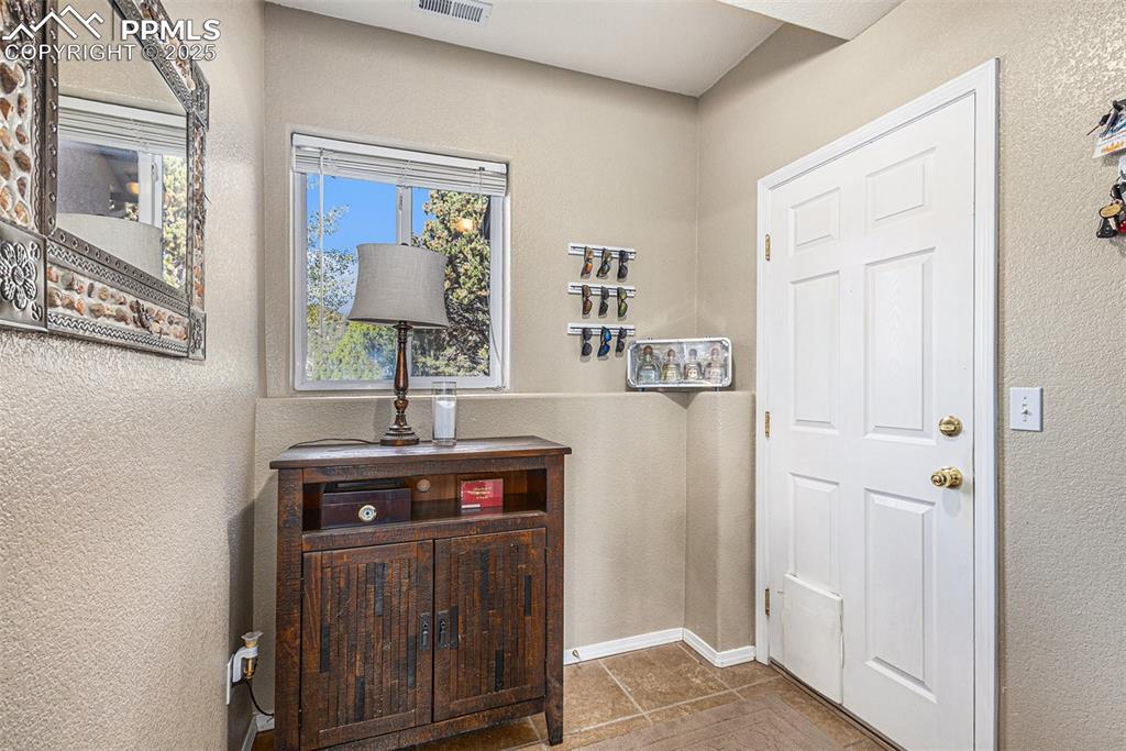 Laundry room featuring washer and dryer, attic access, and a textured wall