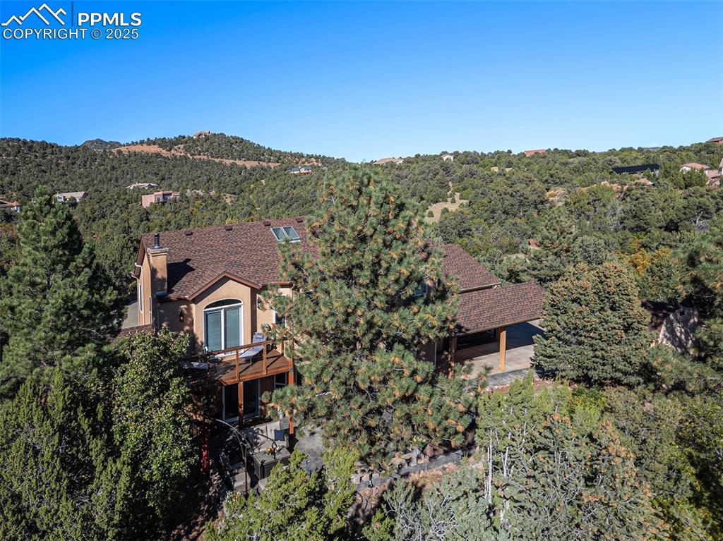 View of subject property with a forest and a mountainous background