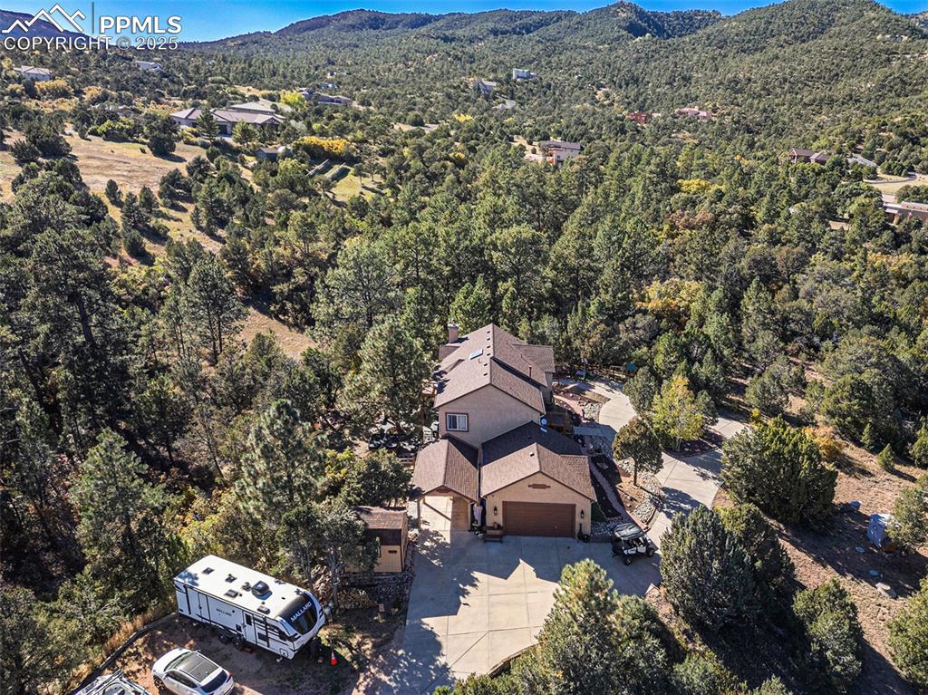 View from above of property with a mountainous background and a forest