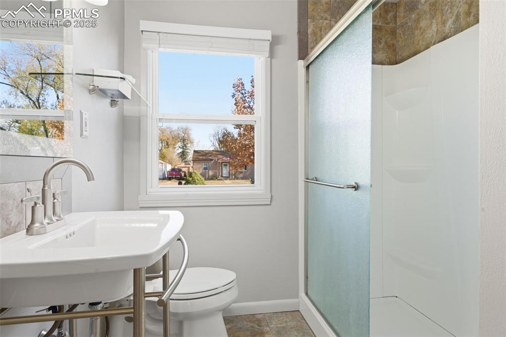 Full bath featuring a stall shower and toilet