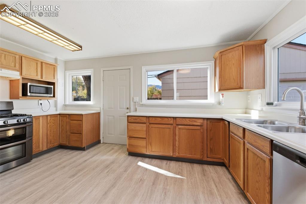 Kitchen featuring stainless steel appliances, light countertops, and healthy amount of natural light