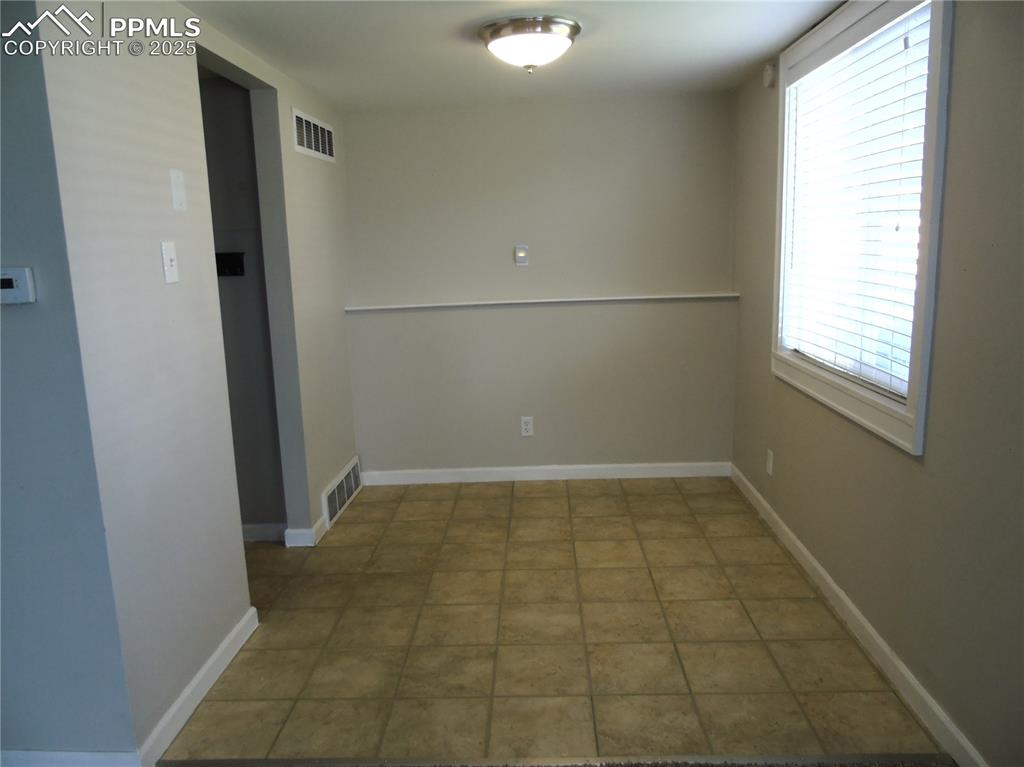 Unfurnished room featuring baseboards and light tile patterned flooring