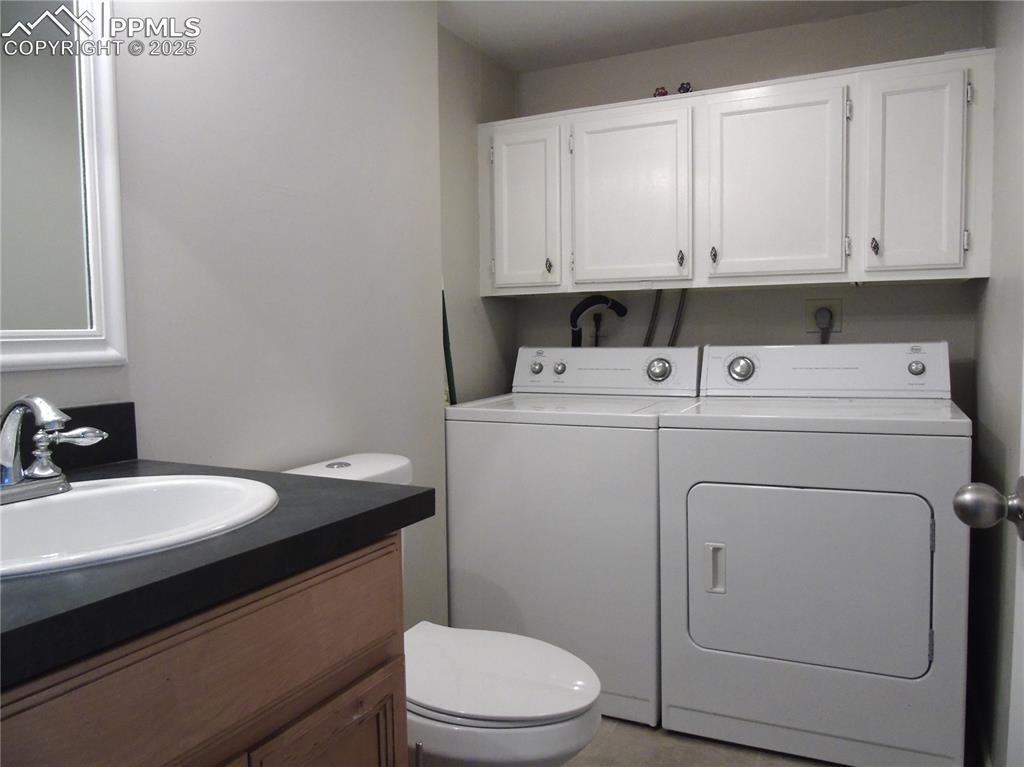 Bathroom featuring vanity, separate washer and dryer, and light tile patterned flooring