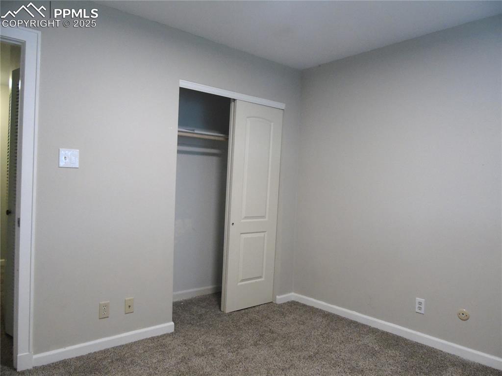 Unfurnished bedroom featuring carpet flooring and a closet