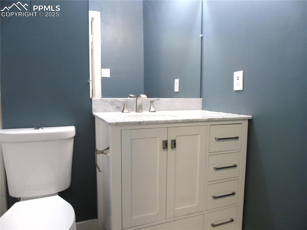 Half bath featuring toilet and vanity