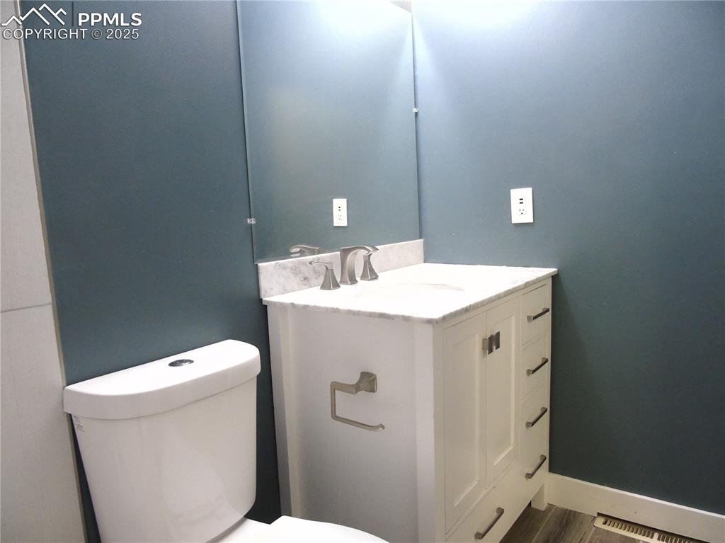 Half bath featuring vanity and wood finished floors