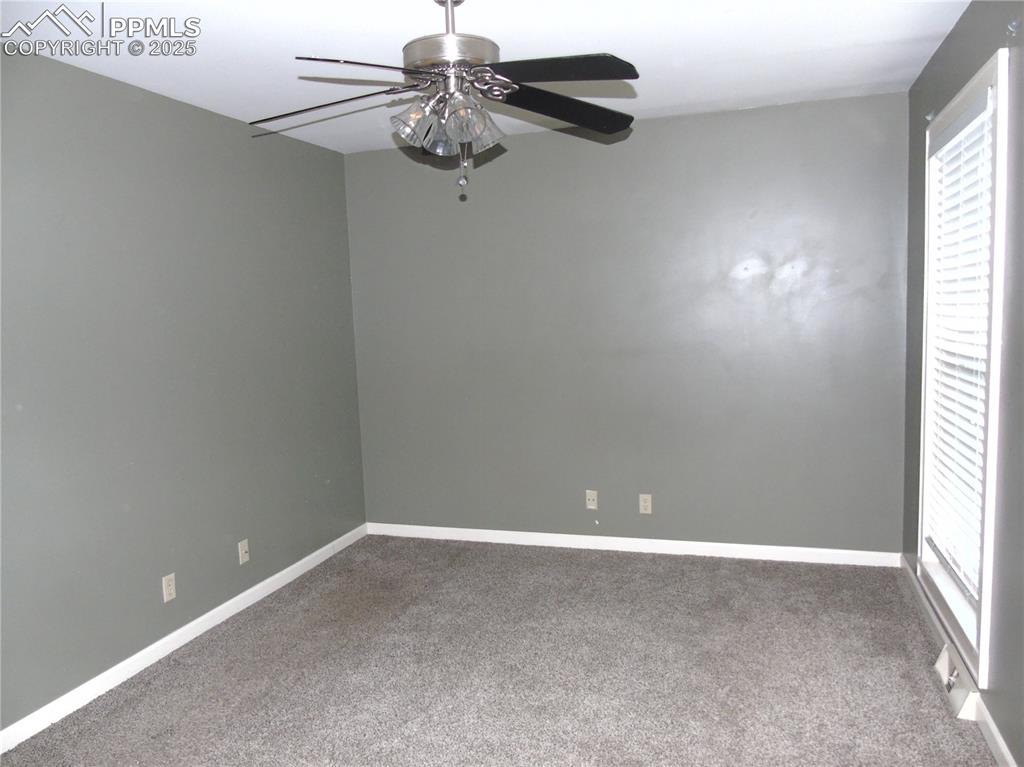 Spare room featuring carpet floors and ceiling fan
