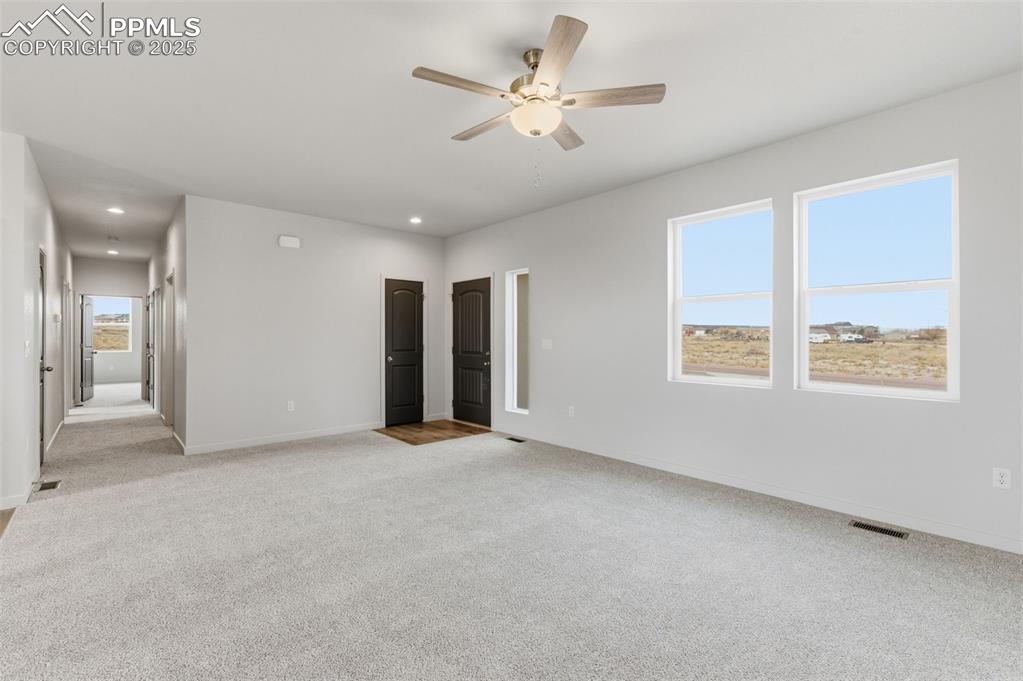 Unfurnished bedroom featuring light carpet, ceiling fan, and recessed lighting