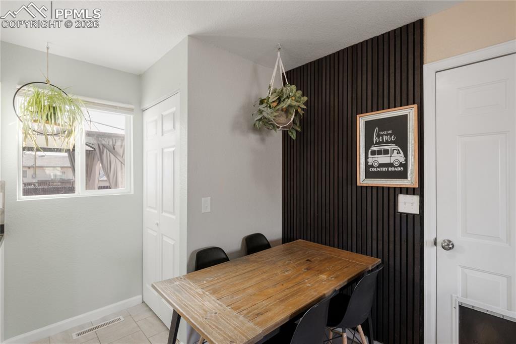 Dining space with baseboards and light tile patterned floors
