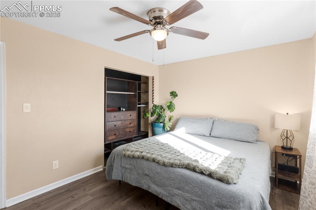 Bedroom with dark wood-style flooring and ceiling fan