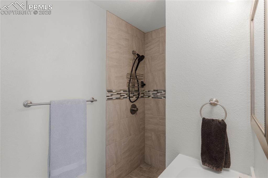 Full bath featuring a tile shower