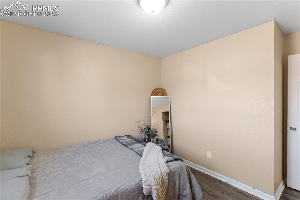 Bedroom featuring wood finished floors and baseboards