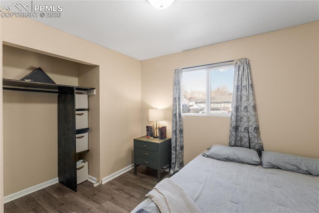 Bedroom featuring dark wood-type flooring and baseboards