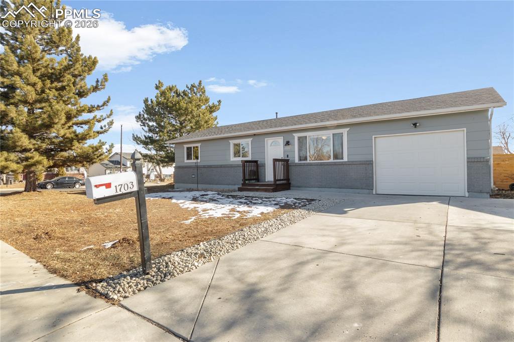 Ranch-style house with driveway, an attached garage, and brick siding