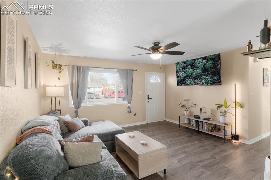 Living area with wood finished floors and ceiling fan
