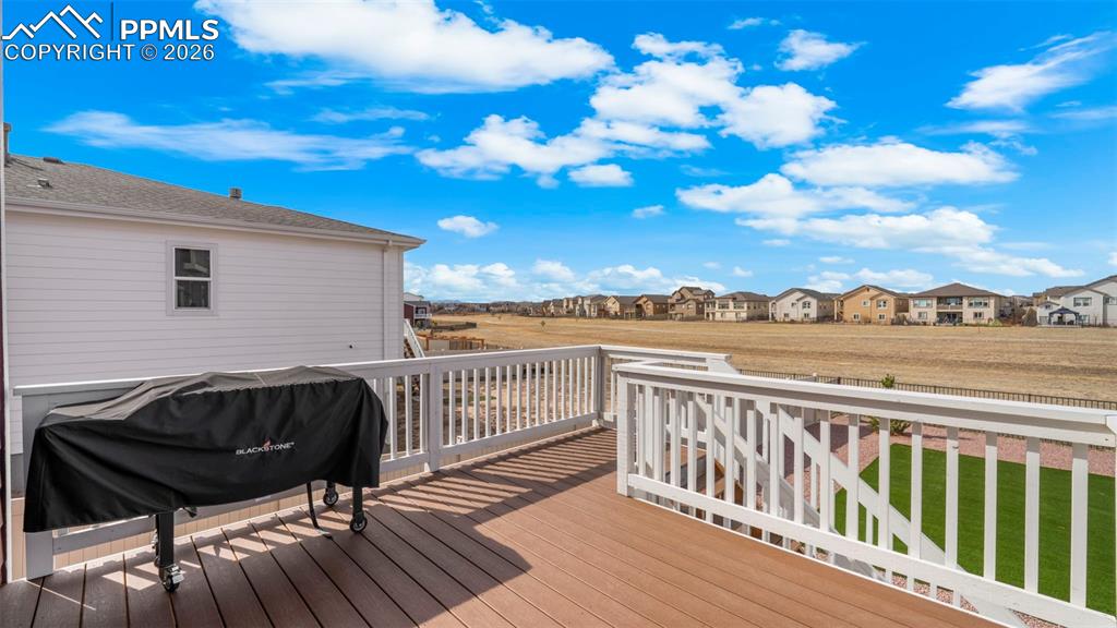 Wooden terrace featuring a residential view and grilling area