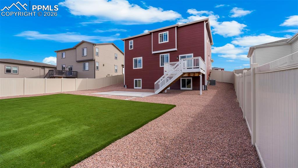 Back of house featuring a patio area, a fenced backyard, and a wooden deck