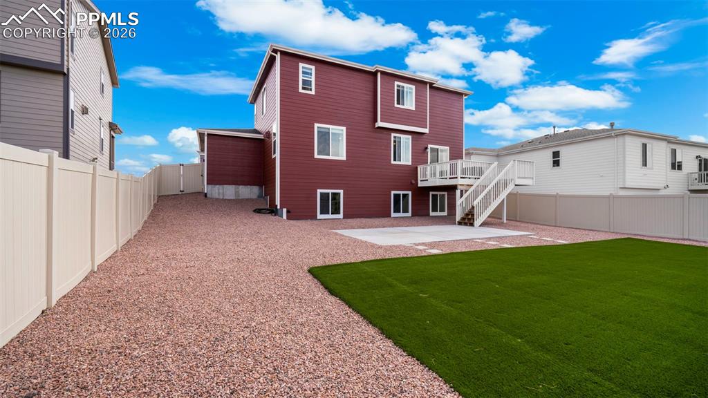 Back of house featuring a fenced backyard, a patio area, and a wooden deck