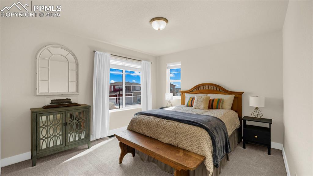 Bedroom with baseboards and light carpet