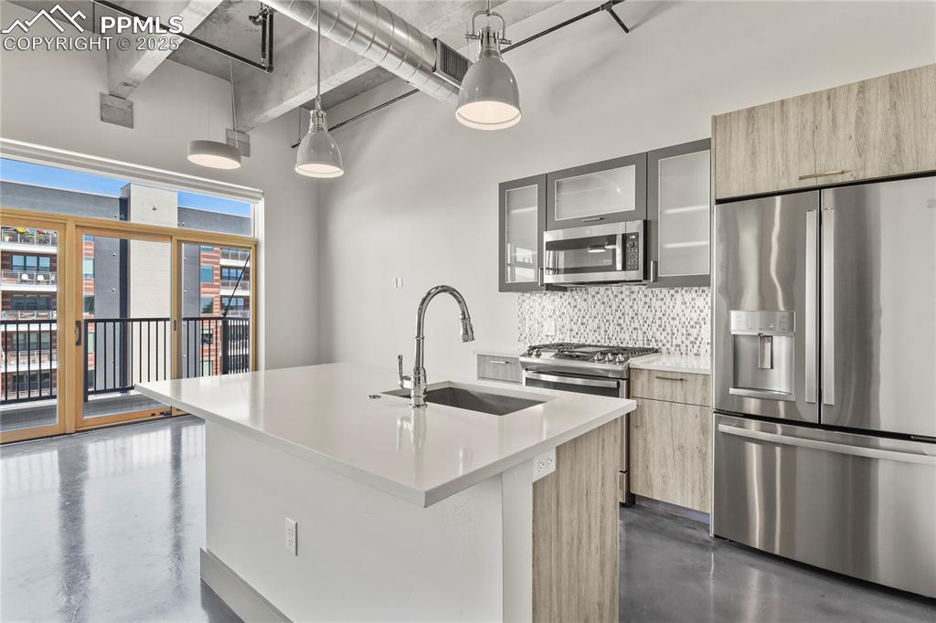 Custom two-toned wood and acrylic cabinetry, quartz counters, large island, and GE stainless appliances