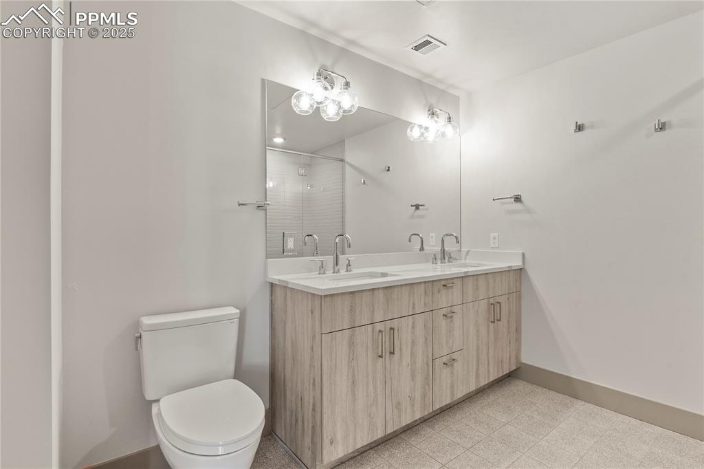 Generously sized bathroom features a double vanity with quartz counters 