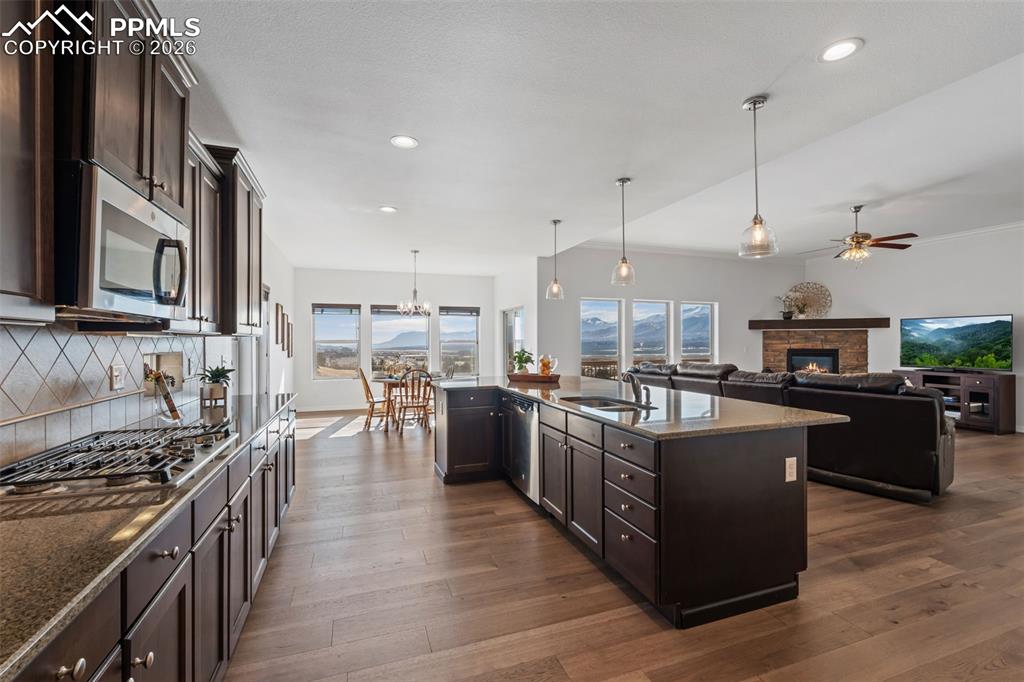 Kitchen featuring dark wood finish cabinets, open floor plan, and dark stone counters