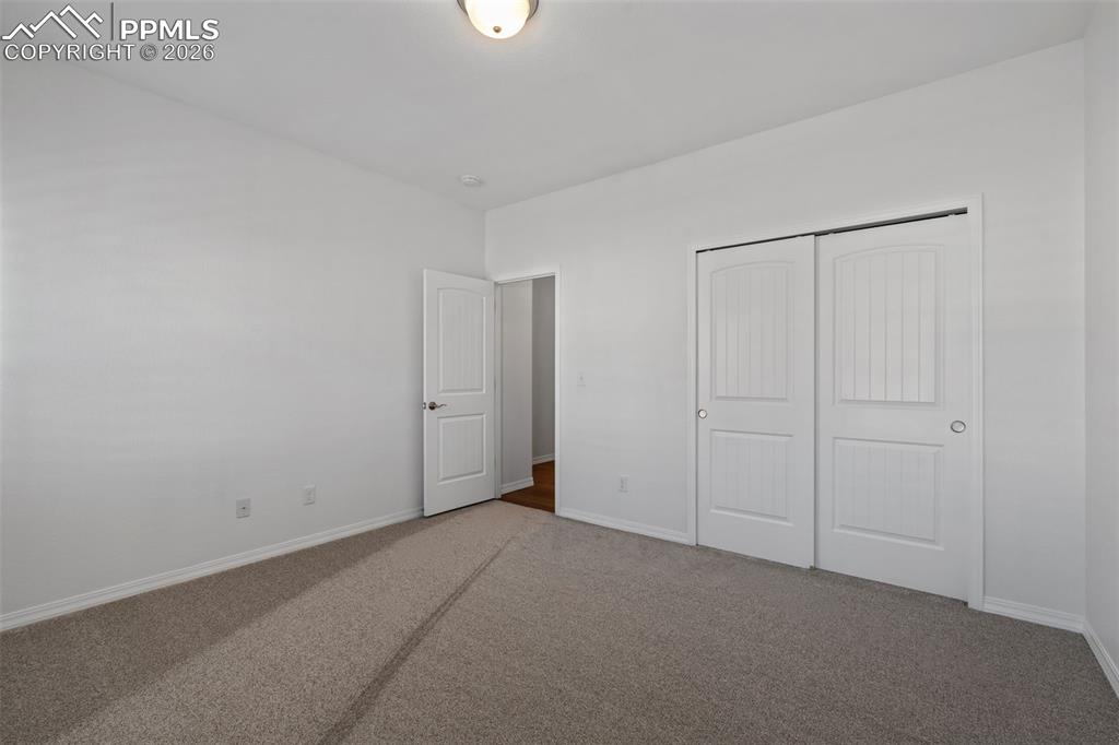 Unfurnished bedroom with carpet flooring and a closet