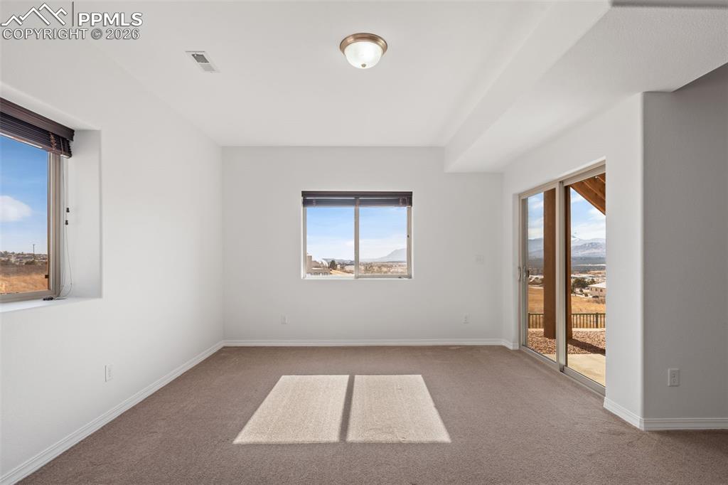 Carpeted spare room featuring baseboards