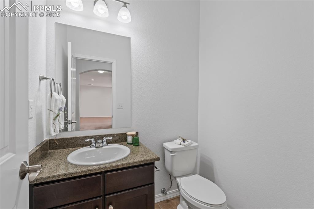 Half bath featuring vanity and a textured wall