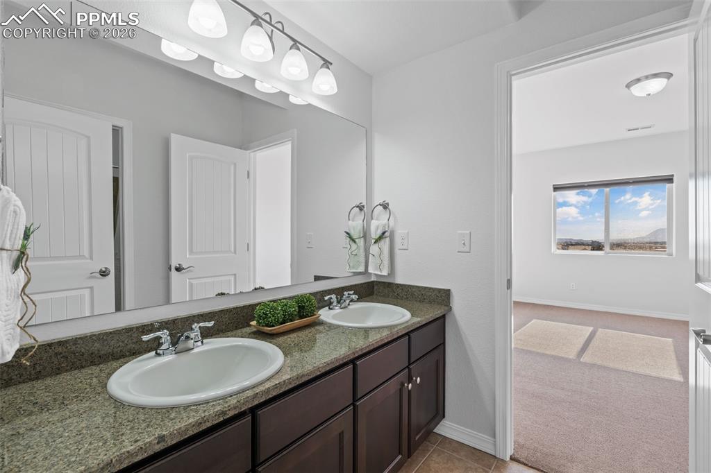 Bathroom featuring double vanity and light colored carpet