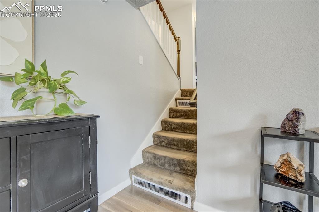 Stairs featuring wood finished floors and baseboards