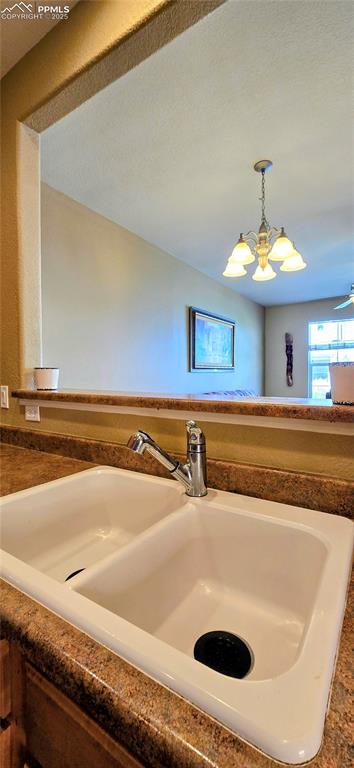 Kitchen view of dark countertops and hanging light fixtures